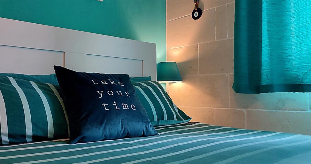 维多利亚Unique New Apartment - Victoria - Gozo的一张带枕头的床,上面写着花时间