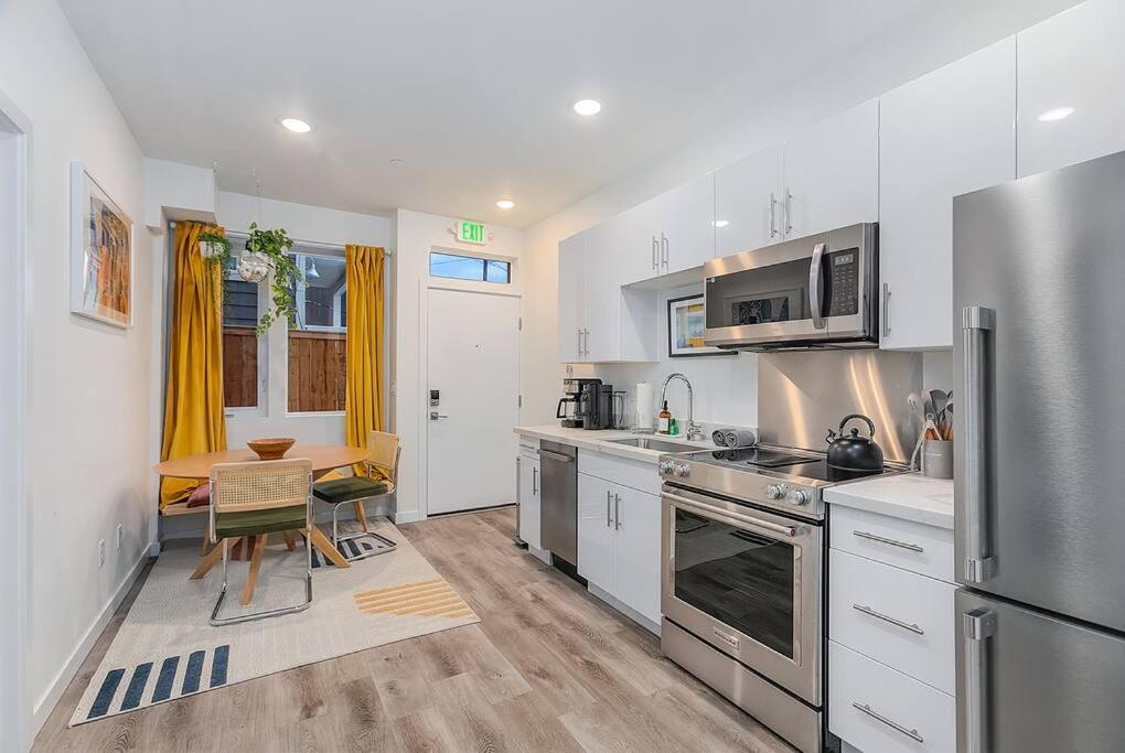 西雅图Calm Urban Abode steps to Volunteer Park的厨房配有不锈钢冰箱和桌子