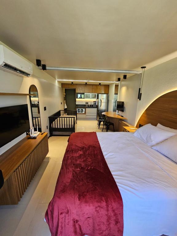 塔曼达雷Praia dos Carneiros flat hotel的一间带大床的卧室和一间客厅