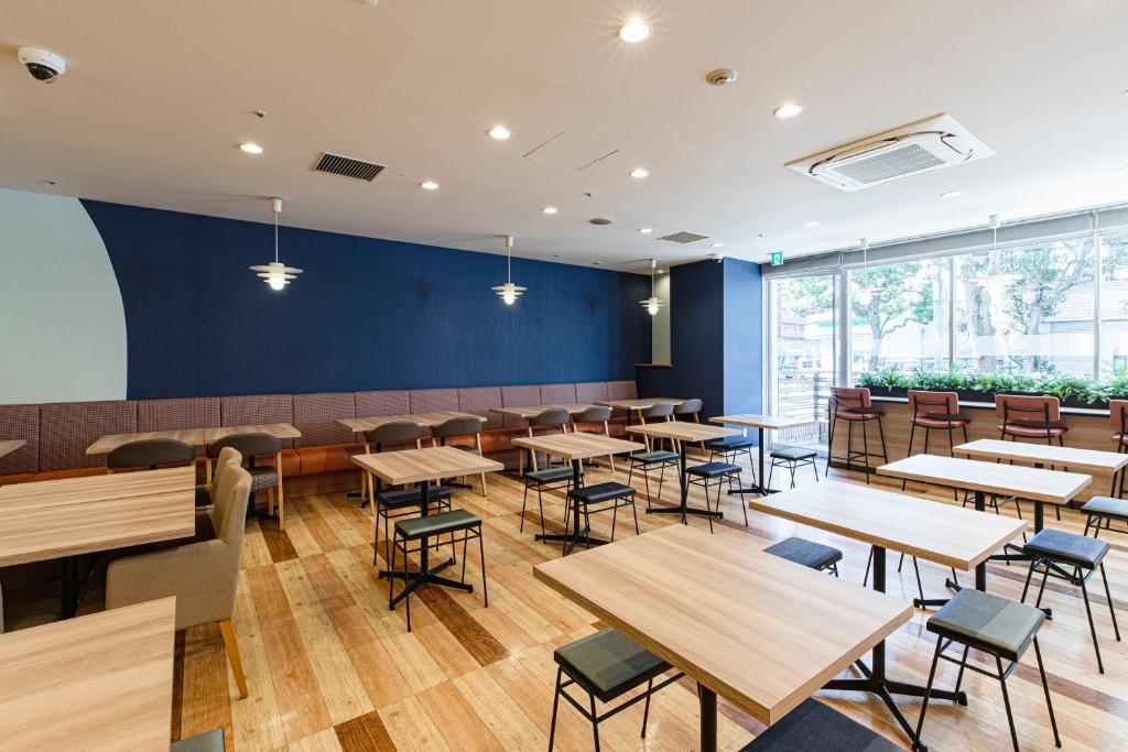 东京卢米埃尔西葛西酒店的用餐室配有木桌和椅子