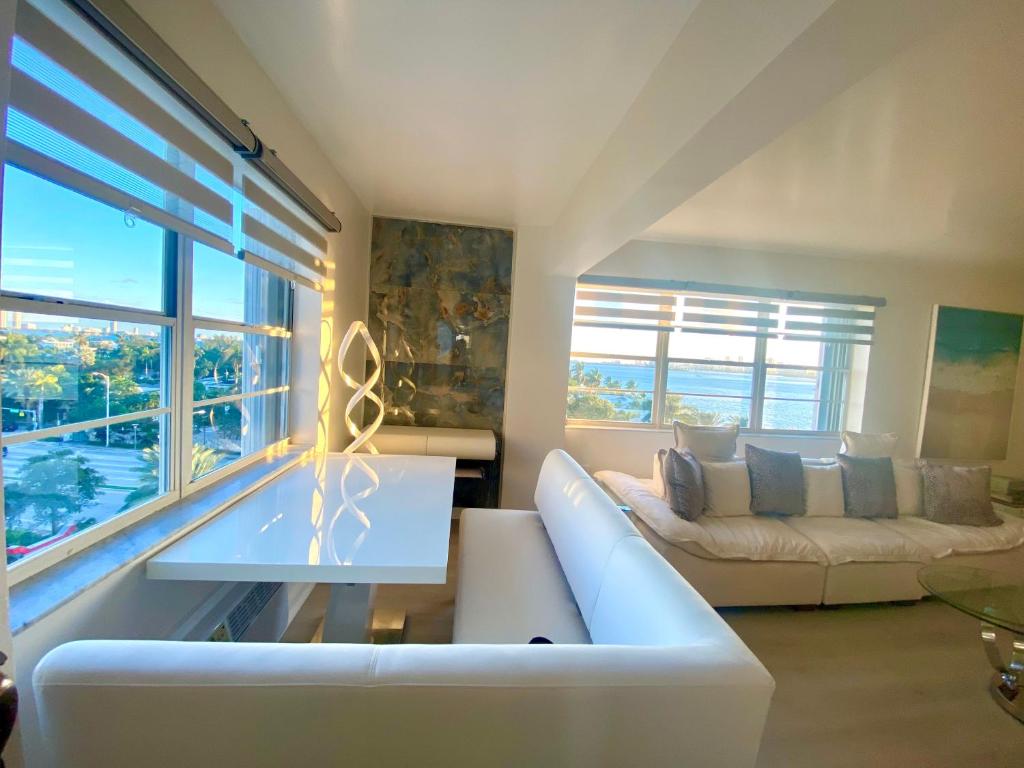 迈阿密海滩Panoramic luxurious waterfront one bedroom apartment with Miami skyline view Free parking 5min drive to Miami Beach的客厅配有白色沙发和大窗户