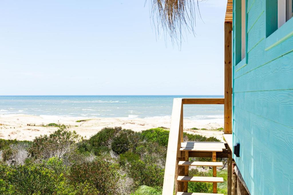 德尔迪阿布罗角Cabaña Agua de Mar的蓝色的房子,设有通往海滩的楼梯