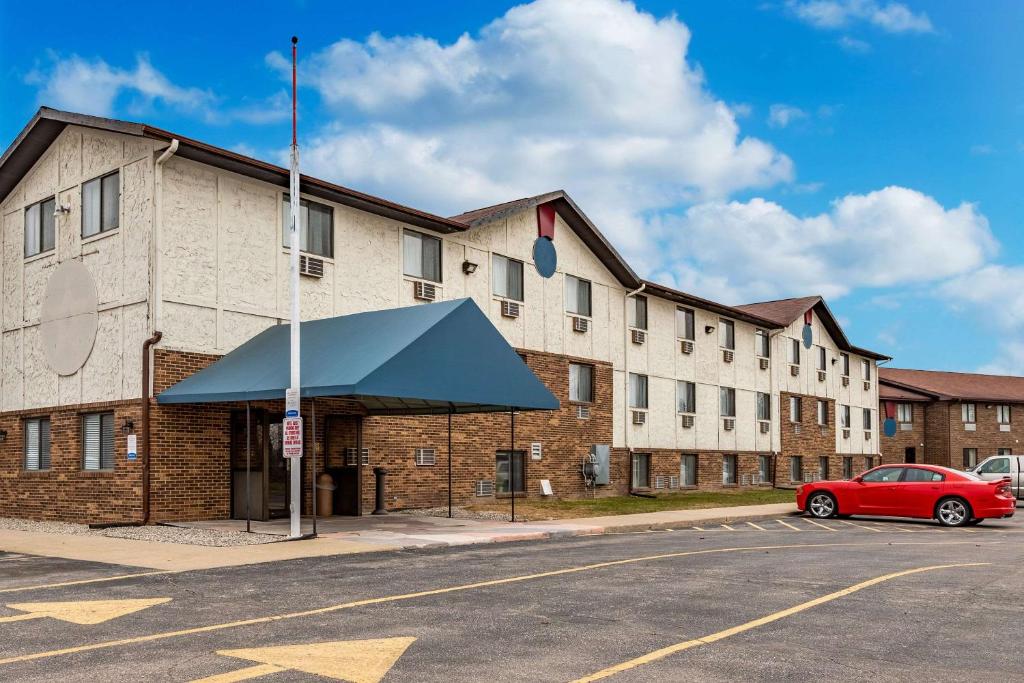 AuburnEcono Lodge Inn & Suites的前面有一辆红色汽车的建筑