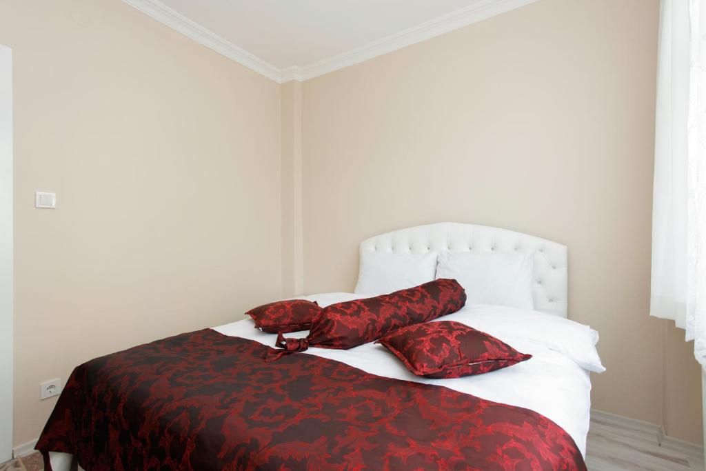 伊斯坦布尔蓝色苏丹公寓式酒店的一间卧室配有一张带红色和黑色床单及枕头的床。