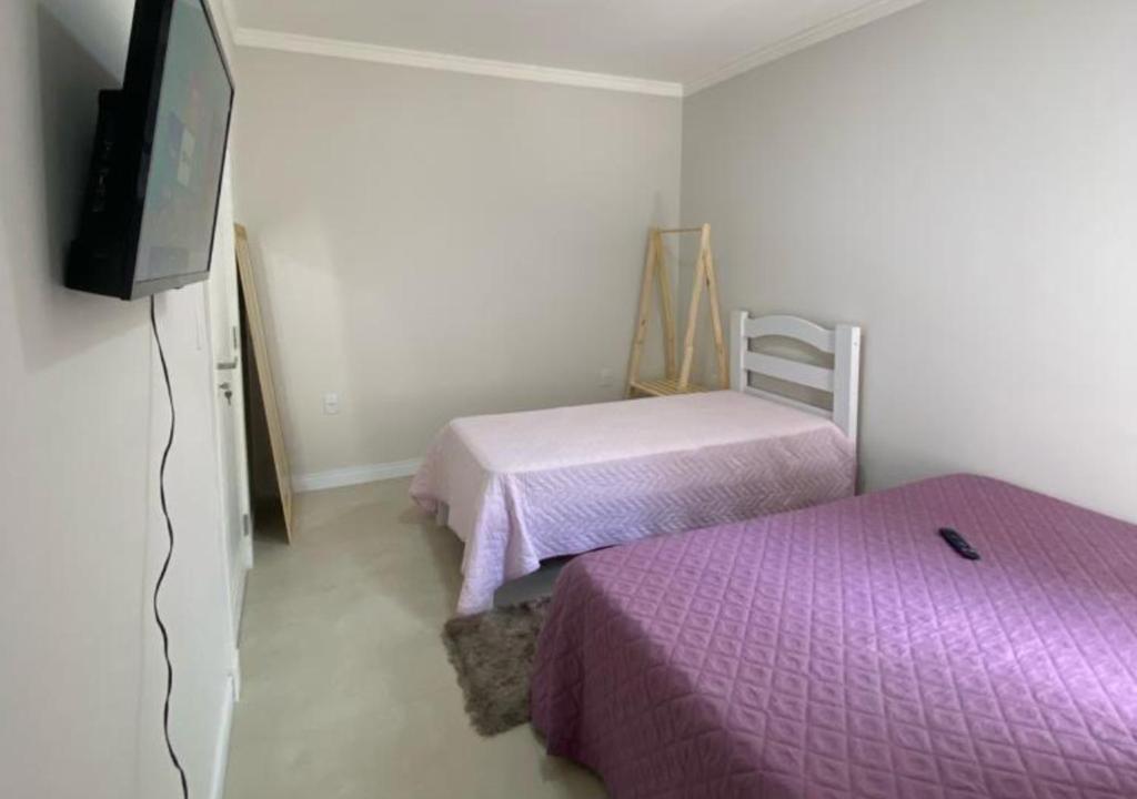 伊达贾伊Suíte Premium的小房间设有两张床和电视