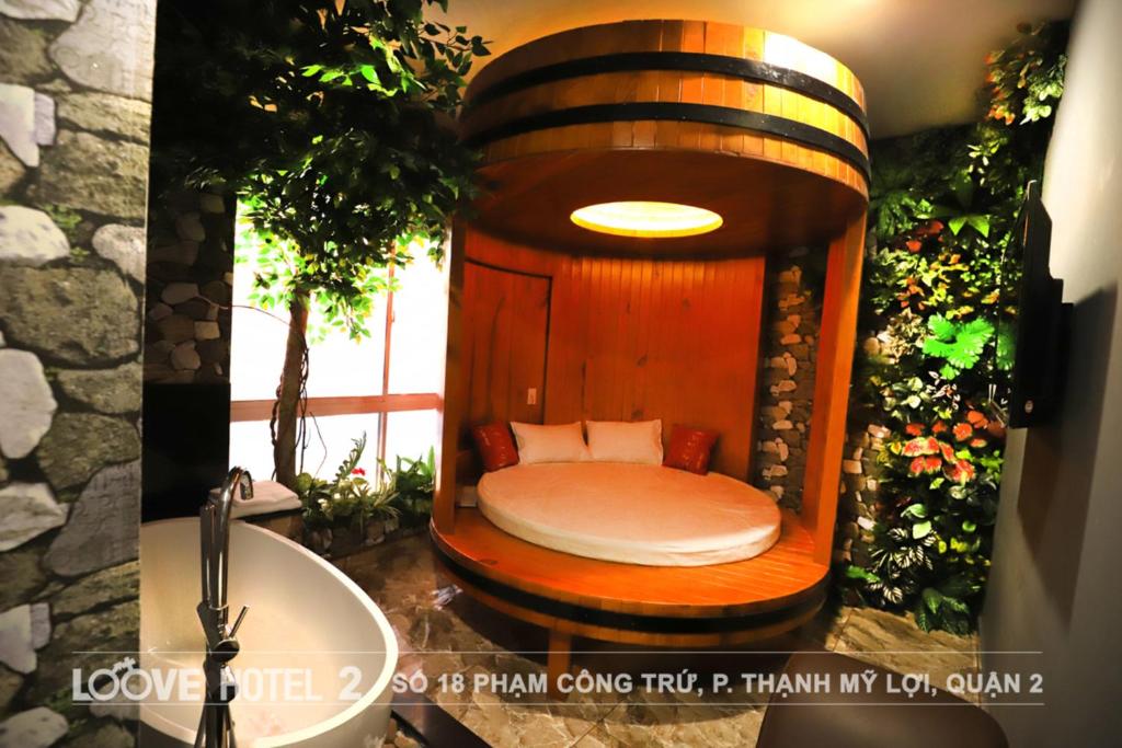 胡志明市Loove Hotel - Khách Sạn Tình Yêu的配有水槽的浴室内的一张小床