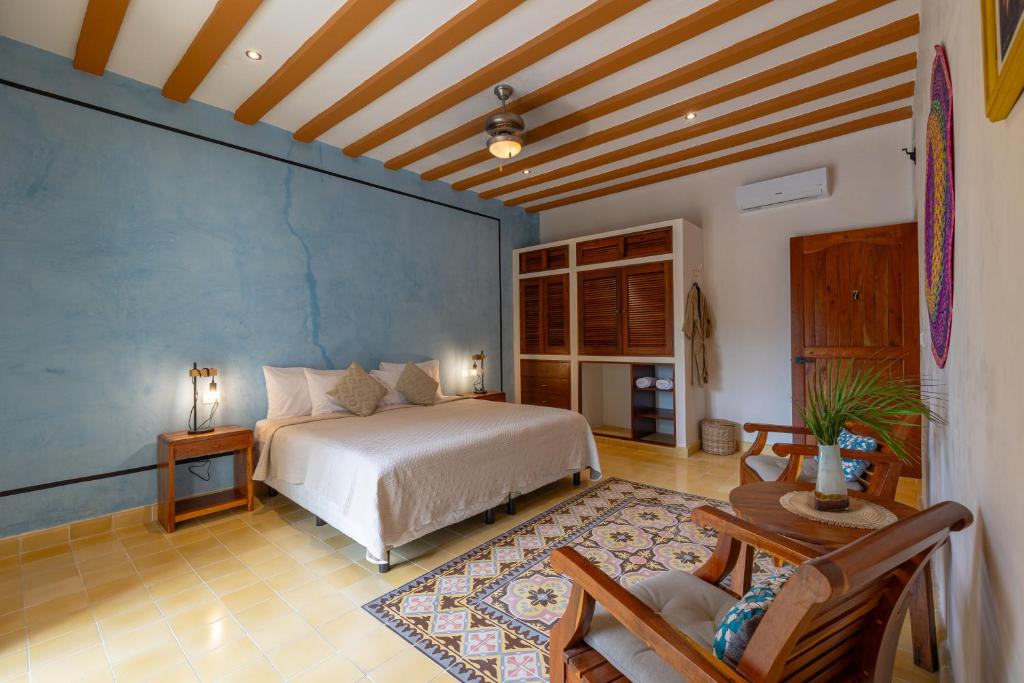 巴利亚多利德Casa Pakal Valladolid的一间卧室设有一张床和蓝色的墙壁