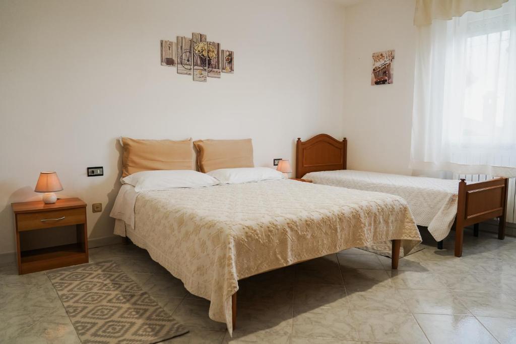 丰尼L Agrifoglio di Rita Loddo的一间卧室设有两张床和窗户。