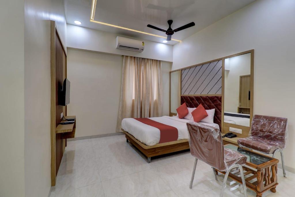 纳威孟买HOTEL VICTORY INN的一间卧室配有一张床、一张桌子和一把椅子