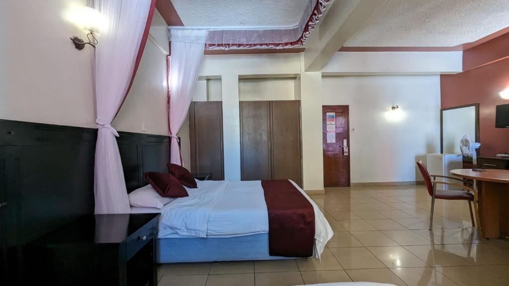 内罗毕Jamia Central Hotel的一间卧室配有一张带粉红色窗帘的床