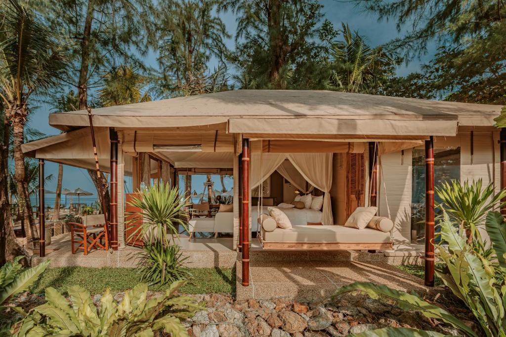 邦涛海滩The Lazy Coconut Glamping的一个带床和帐篷的凉亭