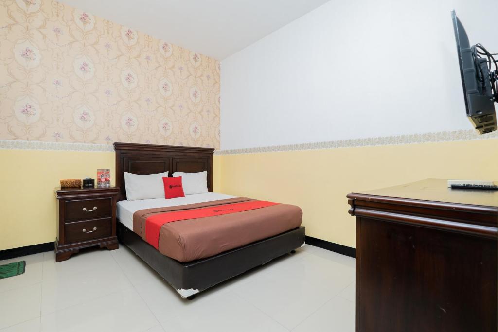 玛琅RedDoorz near Taman Krida Budaya Malang的一间小卧室,配有一张床和一张书桌
