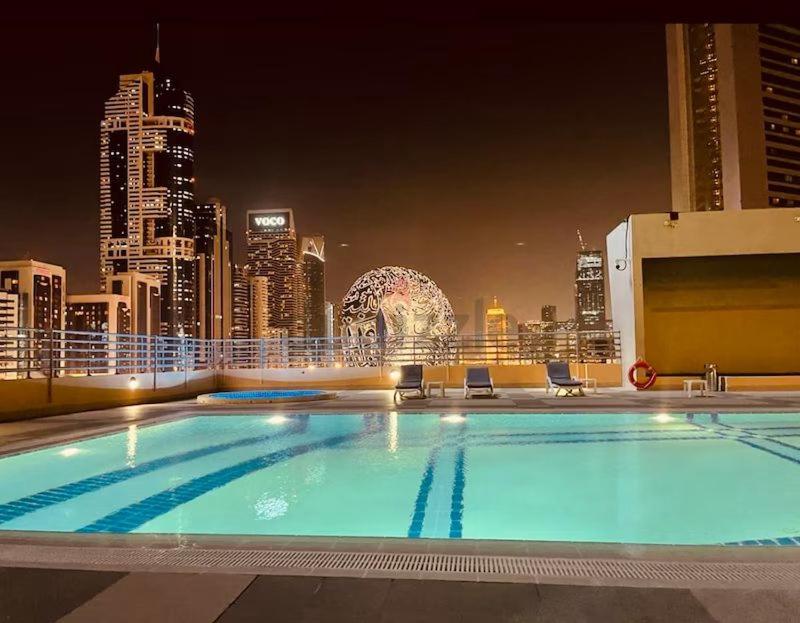 迪拜Amazing 3BR Apartment next to Emirates Towers Metro in DIFC的大楼屋顶上的大型游泳池