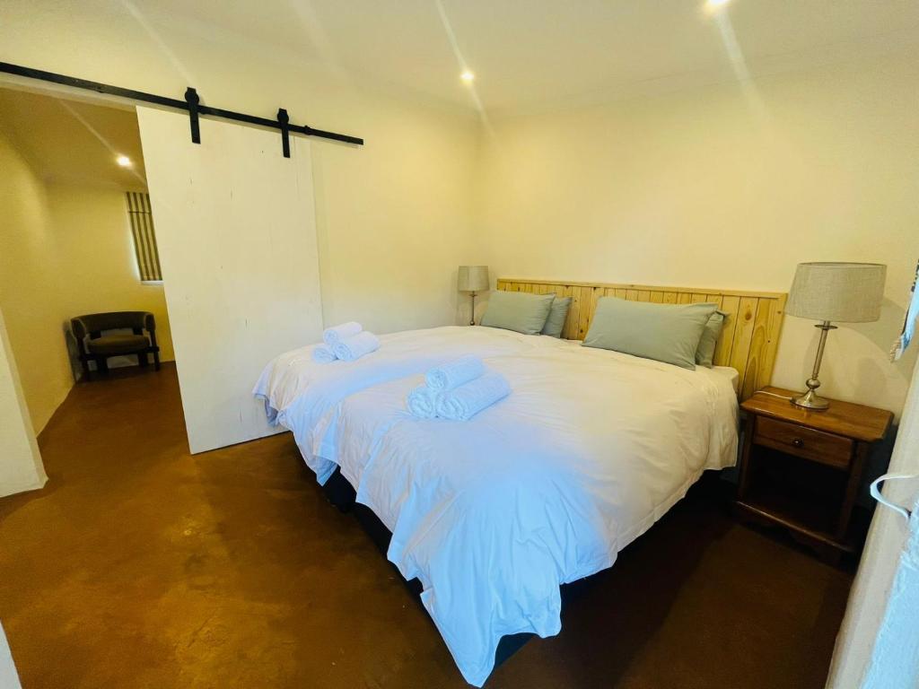 DargleHebron Haven Hotel的卧室配有一张白色大床和两条毛巾