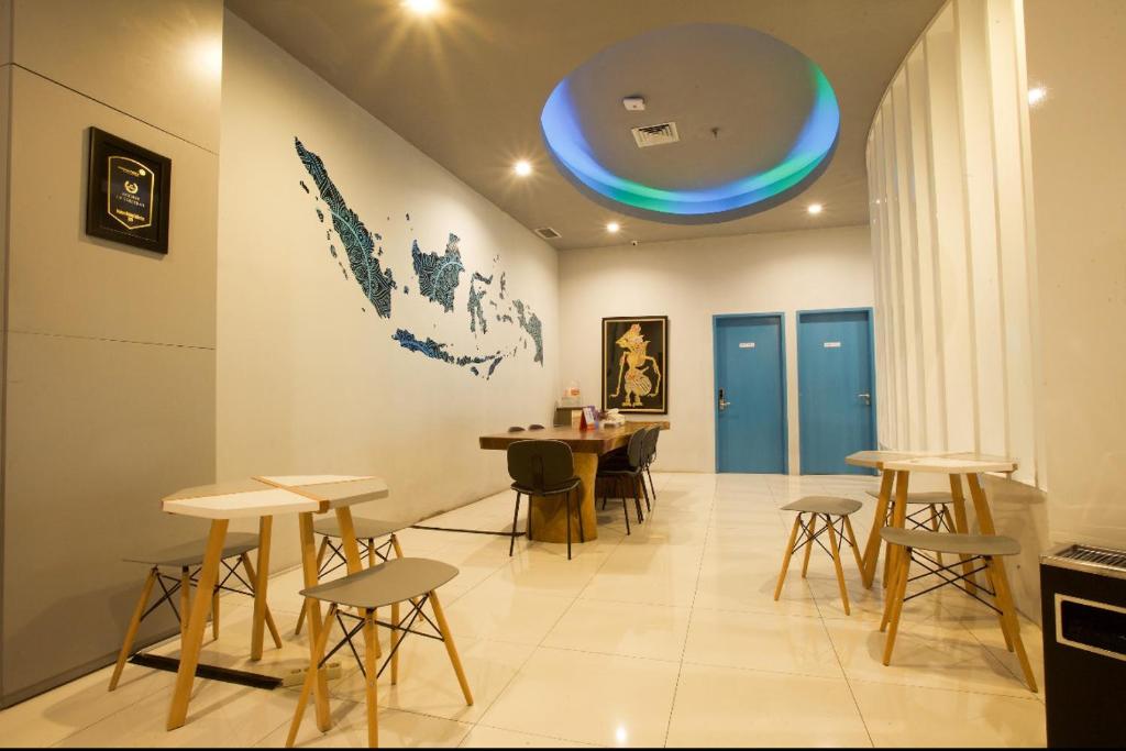 当格浪Digital Airport Hotel的配有桌椅和蓝色天花板的客房