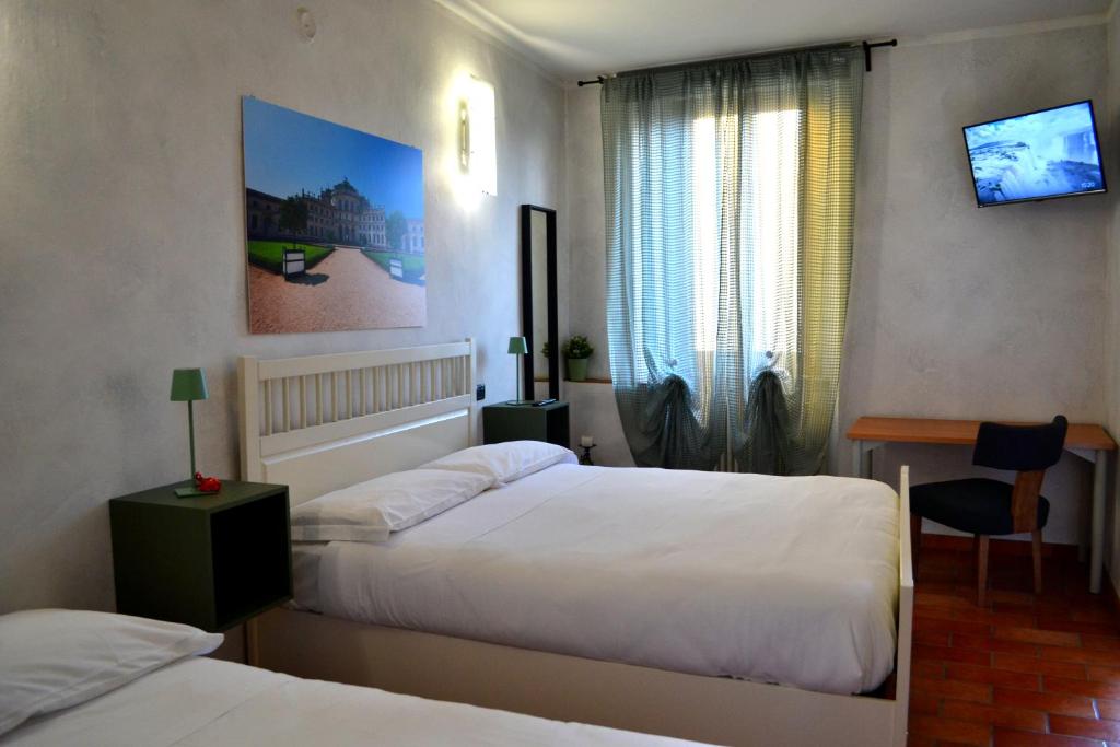 卡塞勒托瑞尼斯DOMUS Hotel的酒店客房设有两张床和窗户。