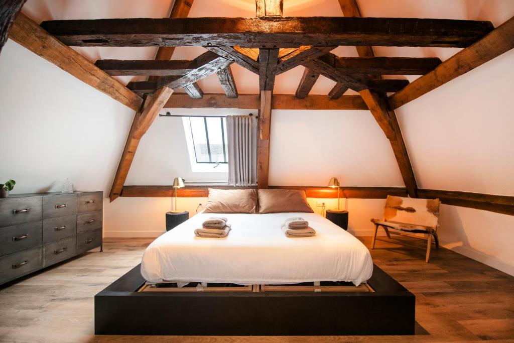 桑斯Le Laurencin Sens - L Authentique的一间带白色床铺的卧室,位于带木制天花板的客房内。
