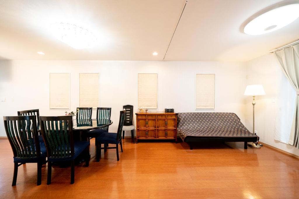 东京Shinokubo guest house的卧室配有一张床和一张桌子及椅子