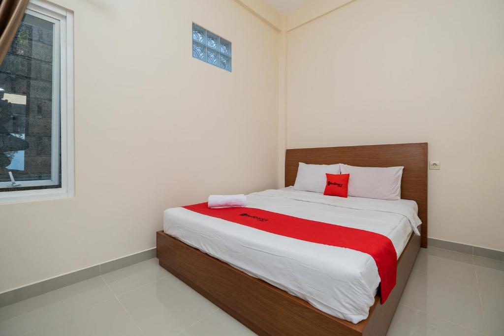 玛琅RedDoorz Syariah near Batu Night Spectacular的一间卧室配有一张带红色毯子的床
