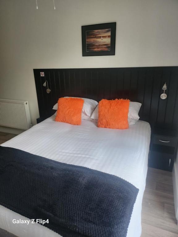 安布尔The Dock Hotel的床上有两个橙色枕头