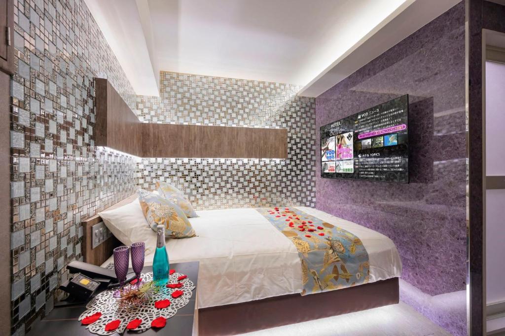 东京Exquisite business hotel Bella的一间卧室配有一张床和紫色的墙壁