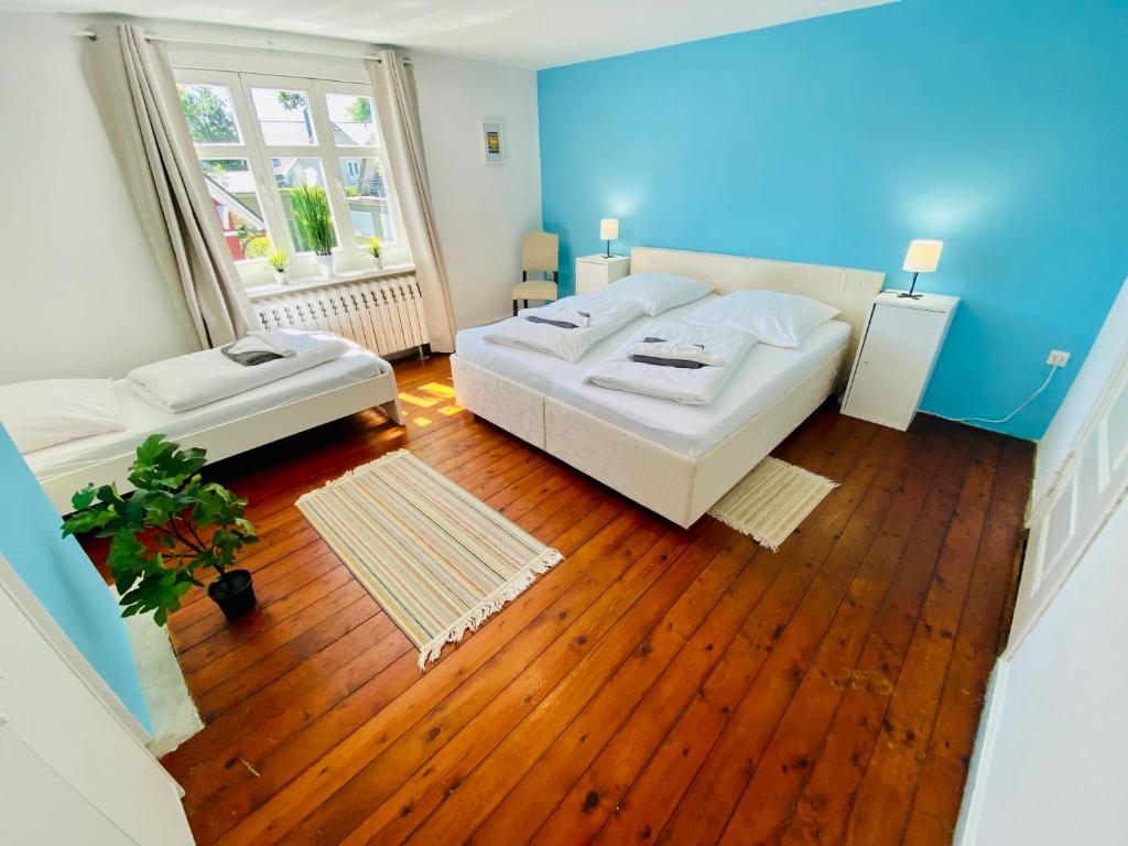 普雷罗OSTSEE-LANDHAUS MÄHL in Prerow mit Sauna und Kamin auch für Gruppen的一间卧室设有两张床和蓝色的墙壁