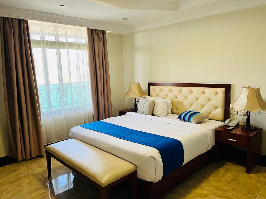 亚的斯亚贝巴Tolip Olympia Hotel的一间设有大床和窗户的酒店客房