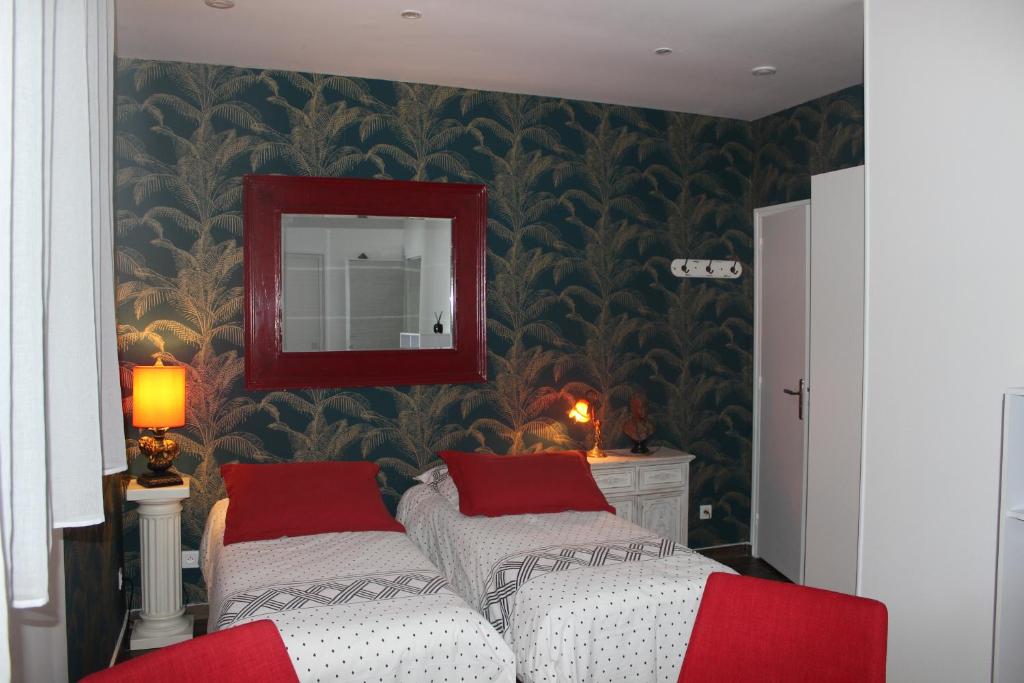马拉科夫PARIS de FLORE Stane的一间卧室配有两张带红色枕头和镜子的床