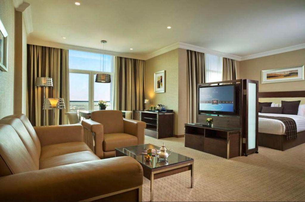 卡尔巴拉Karbala Rayhaan Hotel & Suites的大型酒店客房设有床和电视。