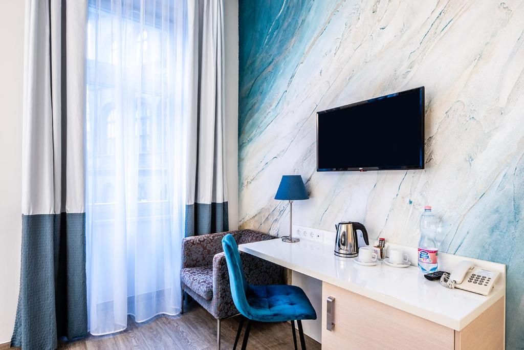 布达佩斯阿特里姆魅力酒店的客房设有书桌和墙上的电视