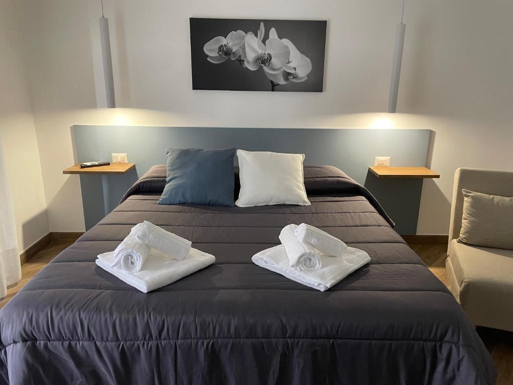 卡尔塔尼塞塔Maiolica Apartment的一间卧室配有一张大床和两条毛巾
