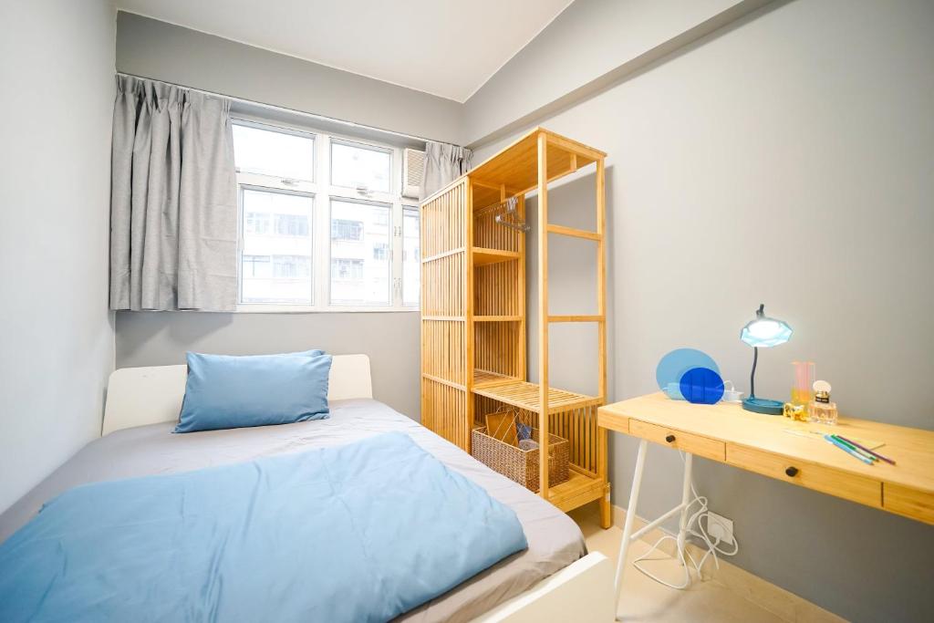 香港Student Accommodation - 292 Hennessy Road的一间卧室配有蓝色的床和一张书桌
