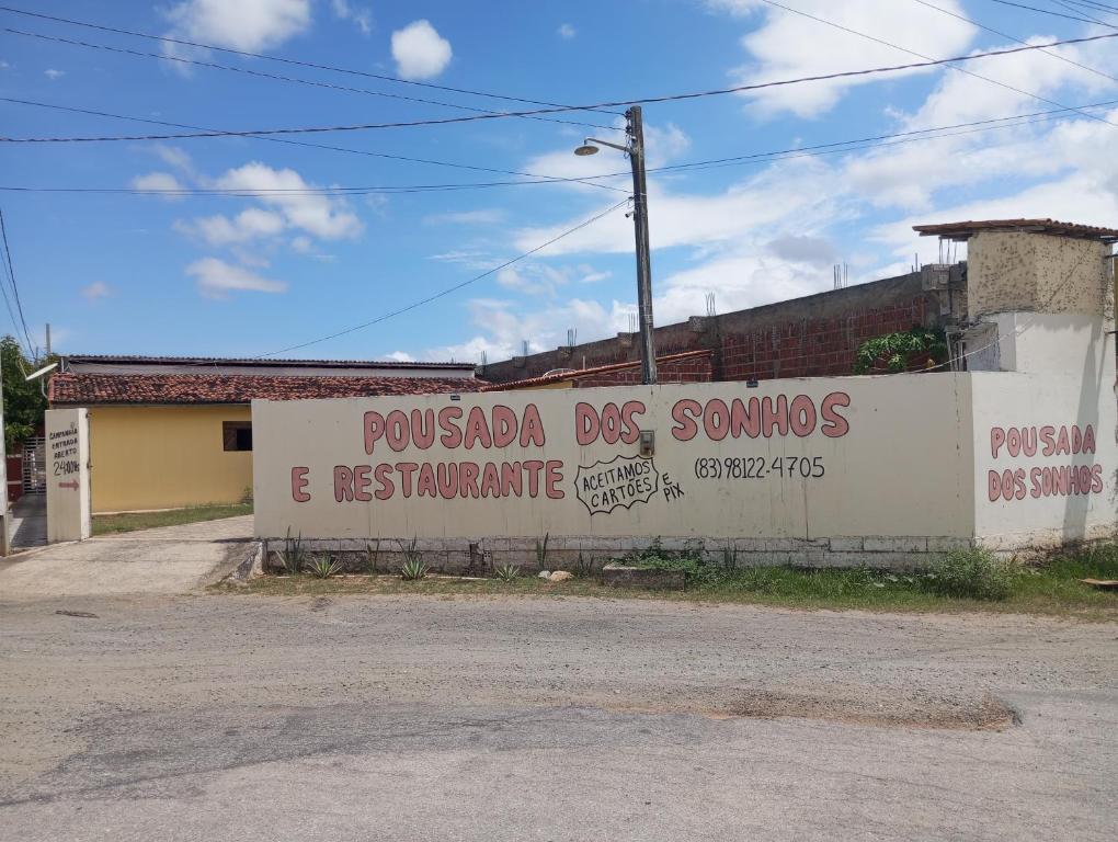 TacimaPousada Dos Sonhos e Restaurante的挂有读过狗烟和餐馆的标志的墙