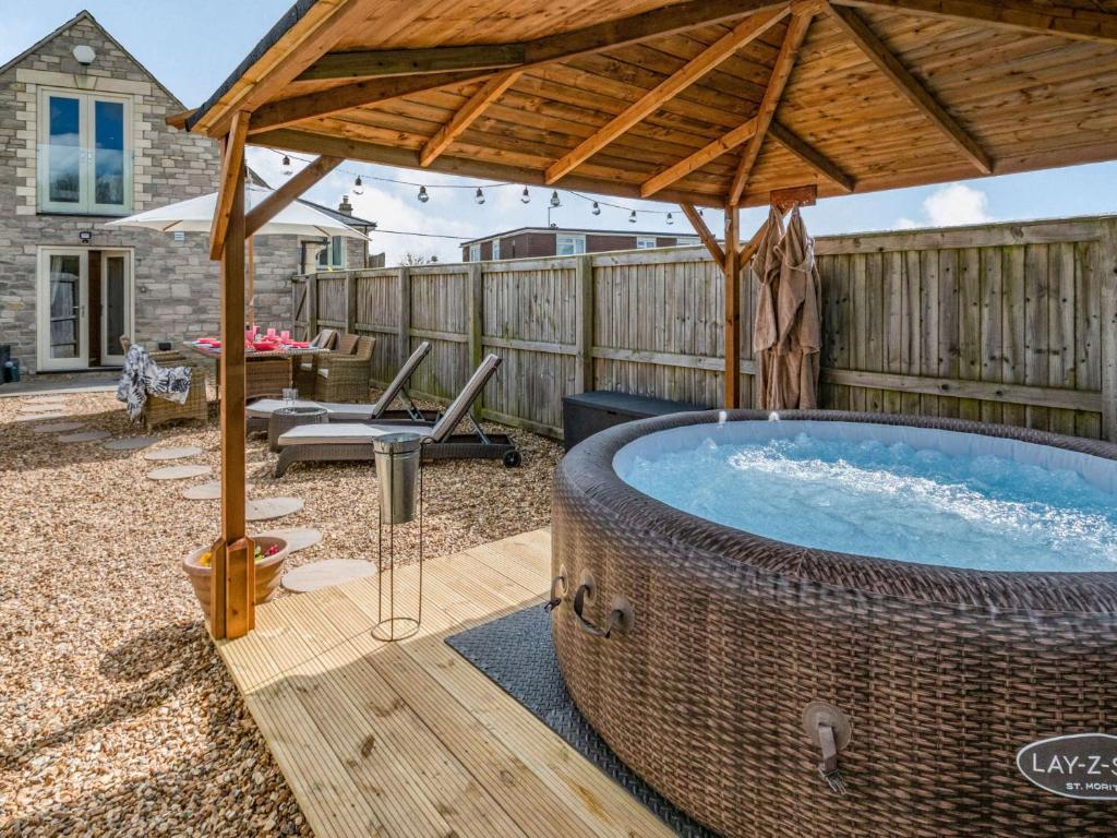 Southwick2 bed property in Bradford-on-Avon 87056的庭院内带木制遮阳伞的热水浴池