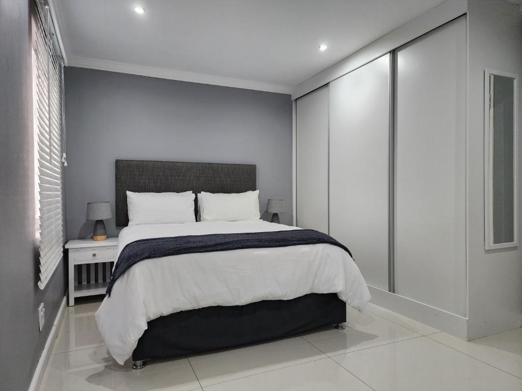 德班Vusi's Guesthouse的一间卧室设有一张大床和一个窗户。