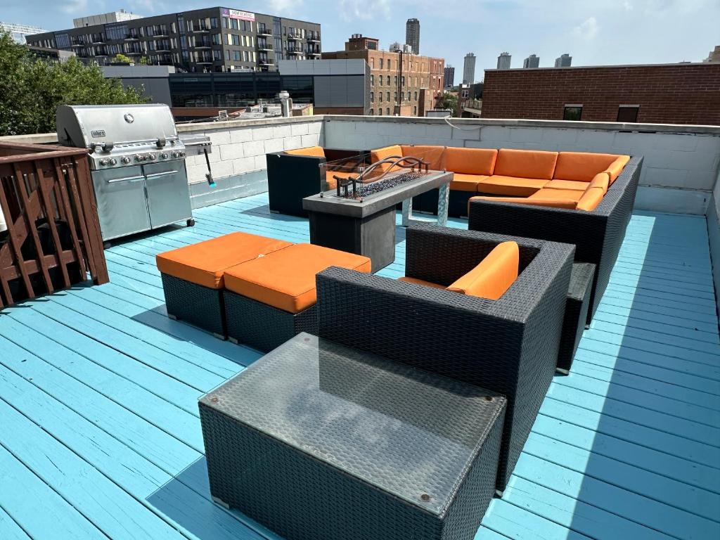 芝加哥Wrigley Penthouse with Private Roof Deck and Parking的屋顶设有家具和屋顶烧烤架