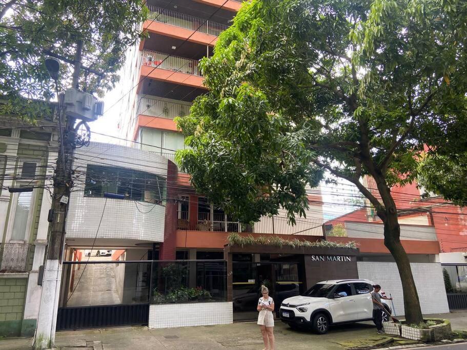 贝伦Apartamento 3 quartos em Belém的站在有车的建筑物前面的女人