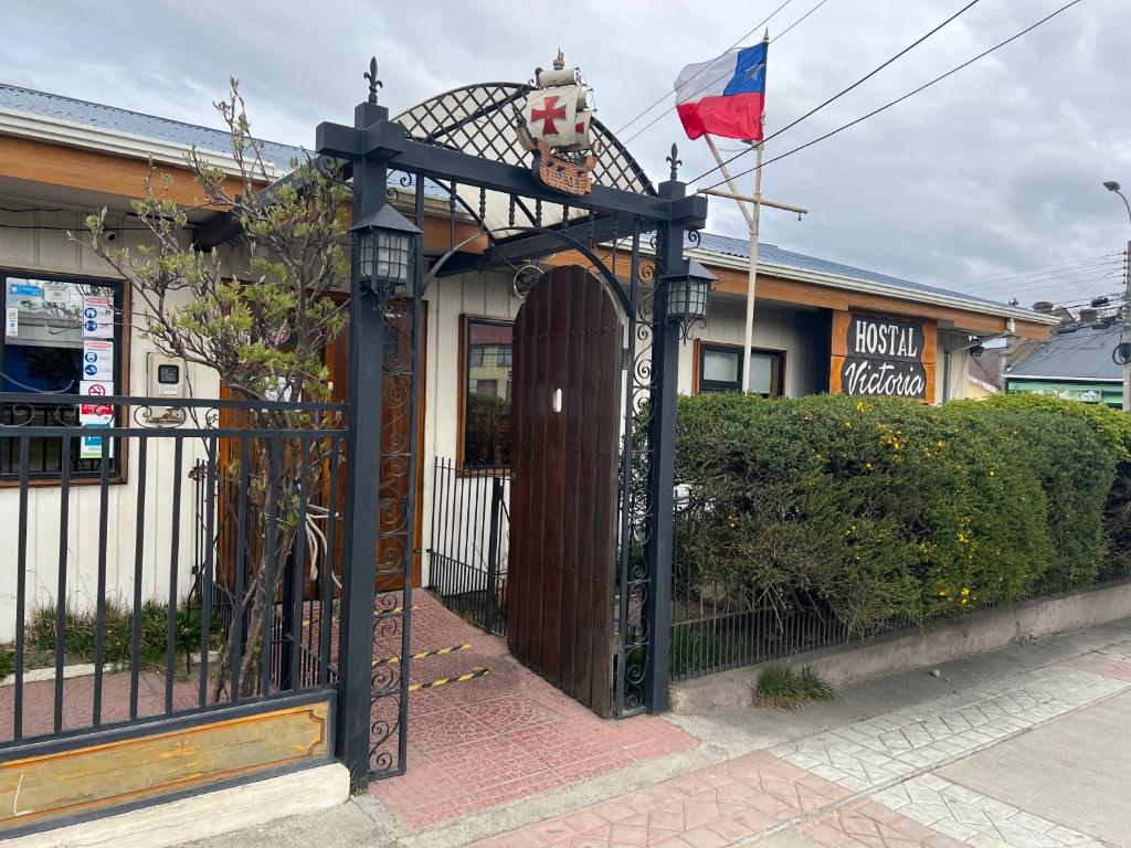 蓬塔阿雷纳斯HOSTAL VICTORIA的房屋前有旗帜的黑色门