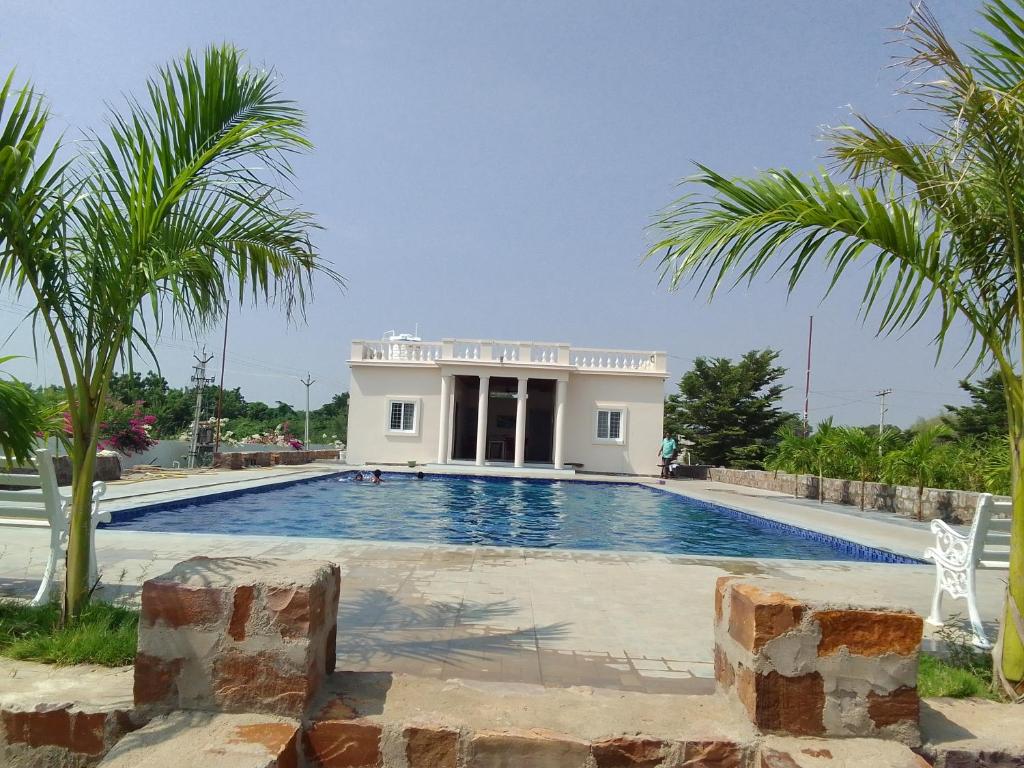 JammalamaduguRivera Resort的一座别墅,设有游泳池和棕榈树