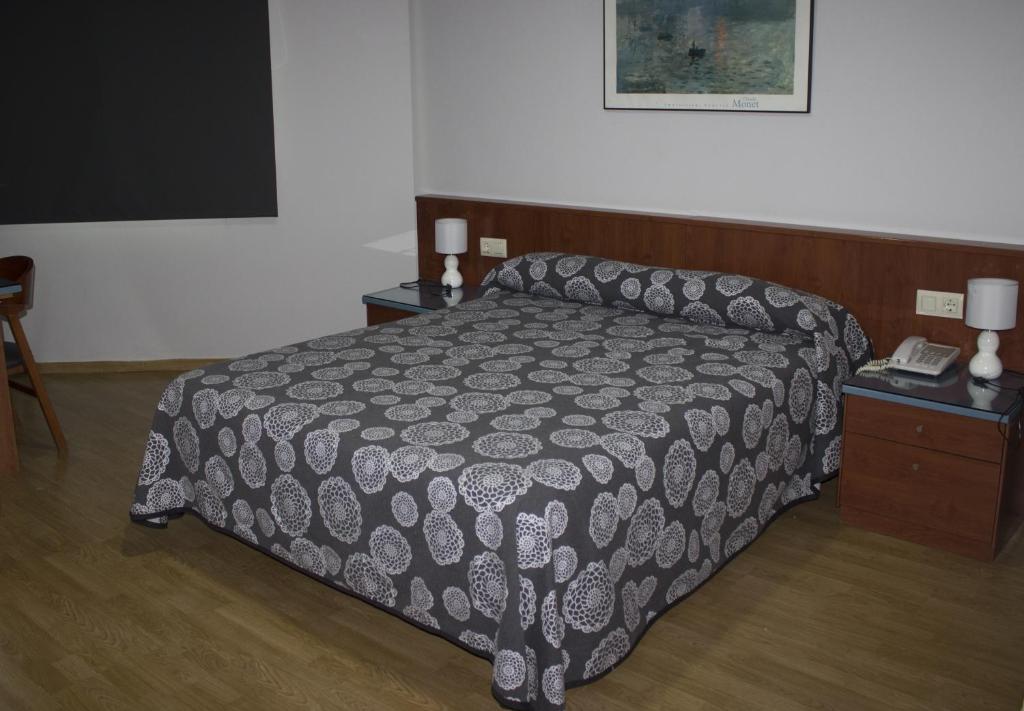 Granja de RocamoraHotel Costa Blanca的一间卧室配有一张床和一张桌子及电话
