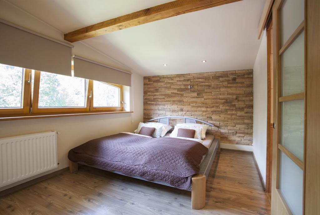 什切尔克Apartament Na Górskiej的一间卧室设有砖墙和一张带枕头的床