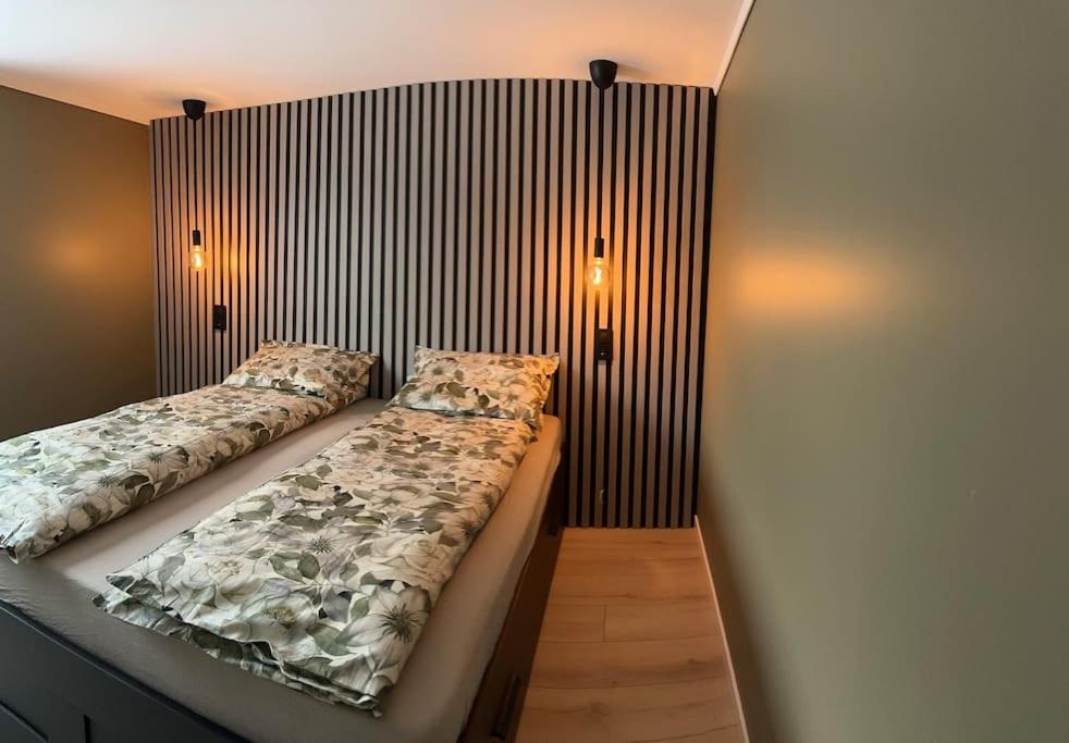特韦德斯特兰Familievennlig Apartment的一间卧室配有两张床,墙上有两盏灯