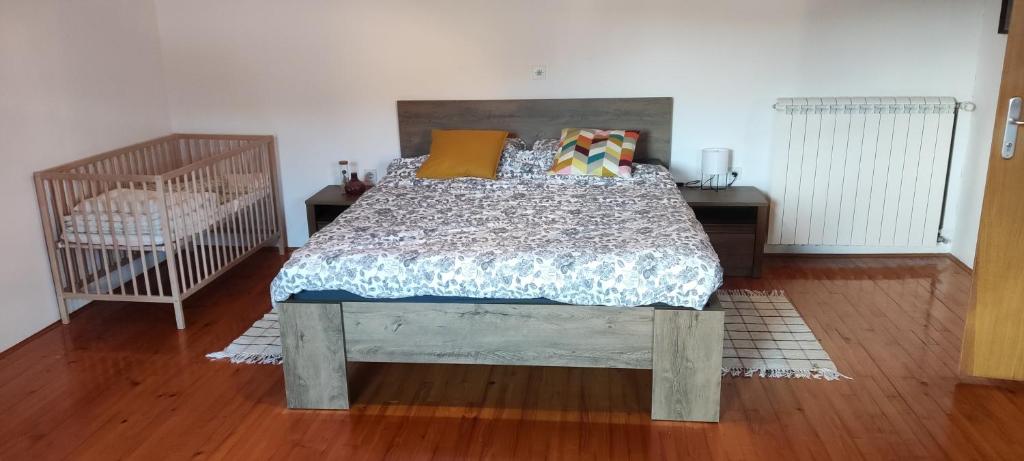 皮夫卡Family Hostel Pivka的一间卧室配有一张床和一张婴儿床