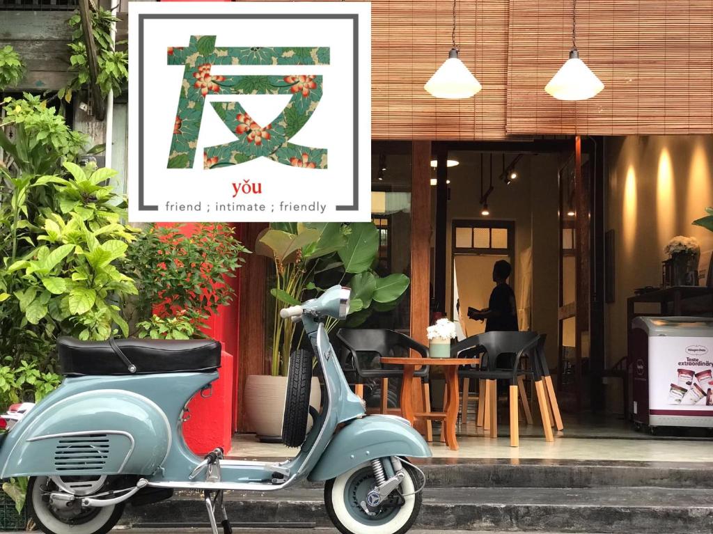 宋卡Yu Cafe Hostel的停在餐厅前的摩托车