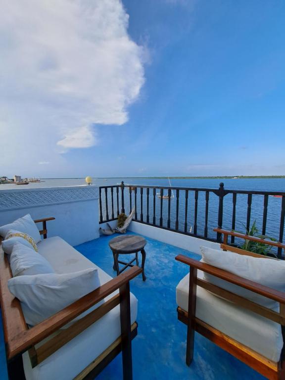 拉穆Pwani House - Lamu Seafront的阳台配有沙发,享有海景
