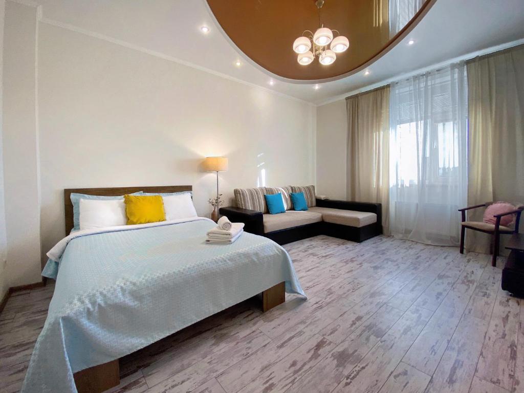 基辅Чарівна, простора квартира в 2хв від МВЦ, Лівобережна的一间卧室配有一张大床和一张沙发