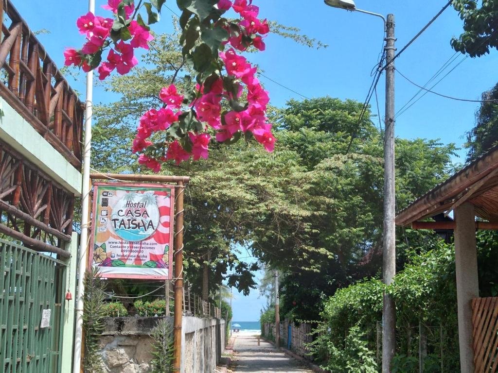 蒙塔尼塔Hostal Casa Taisha的一条有标志和粉红色花的街道