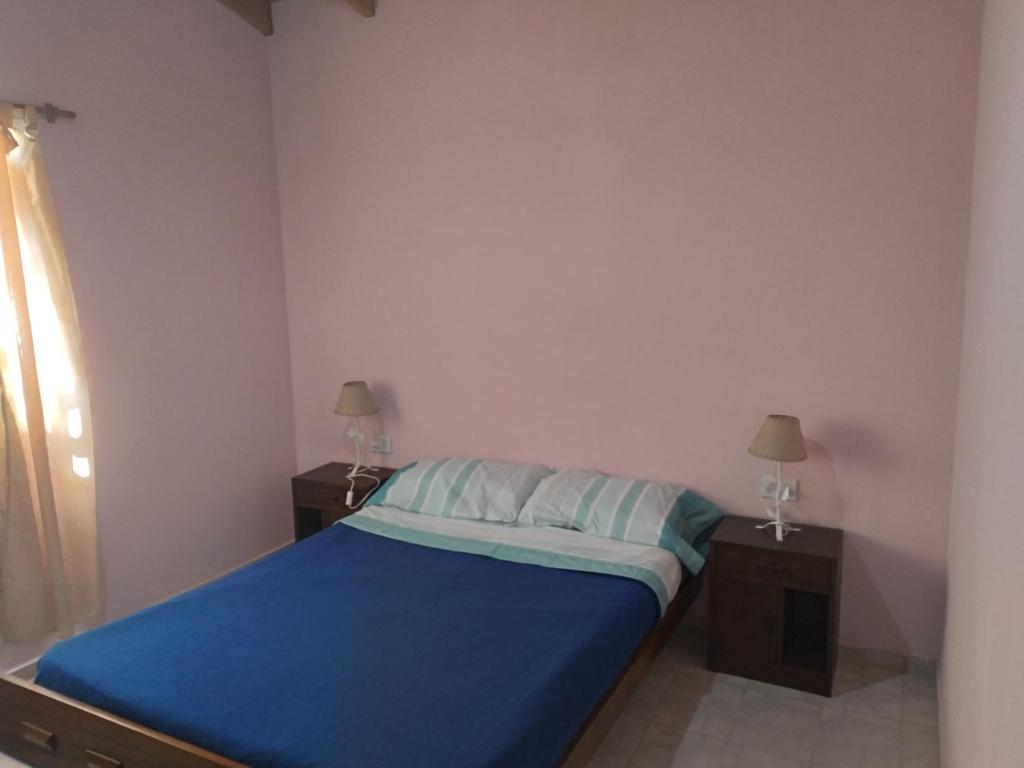 别德马Km 9的一间卧室配有一张带蓝色床单的床和两张桌子