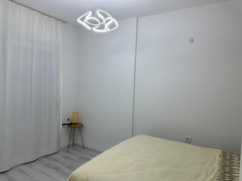 MenemenÖzlem my Home的一间卧室设有一张床和白色的墙壁