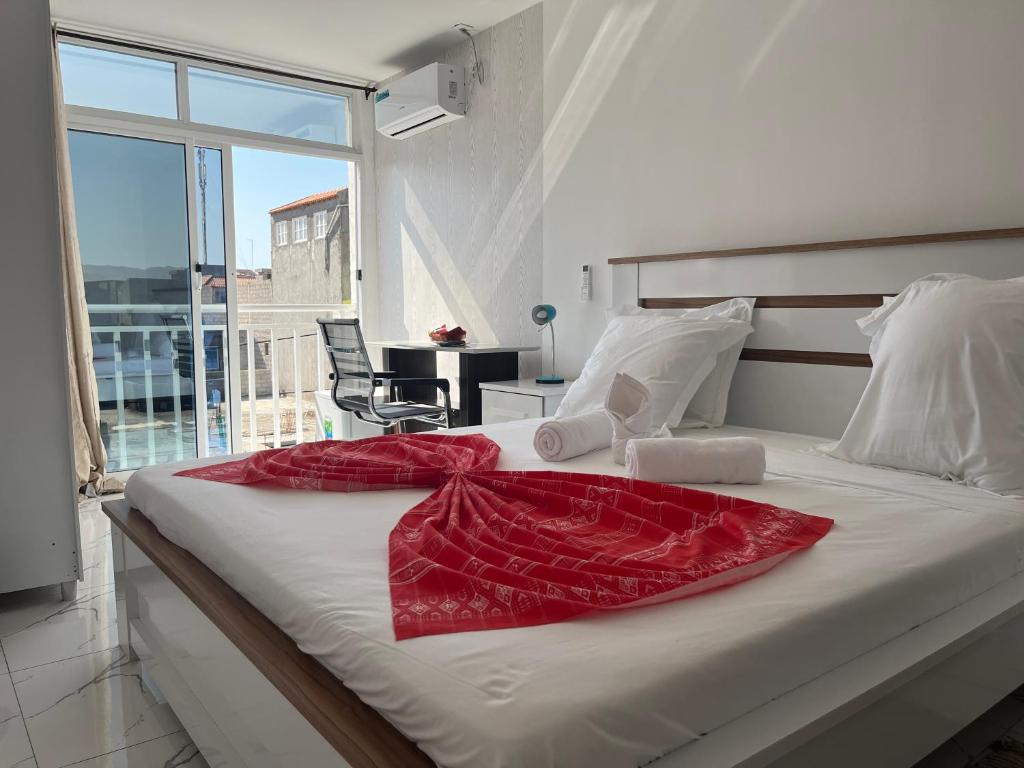 塔拉法尔Hotel Principal的一间卧室配有一张床铺,床上铺有红色毯子